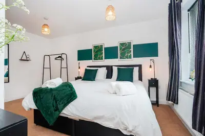 a bedroom with a large bed with green and white pillows at Yew Tree Close Mildenhall Bury St Edmunds in Mildenhall