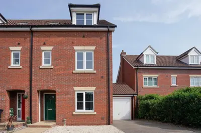 a red brick house with a white garage at Yew Tree Close Mildenhall Bury St Edmunds in Mildenhall