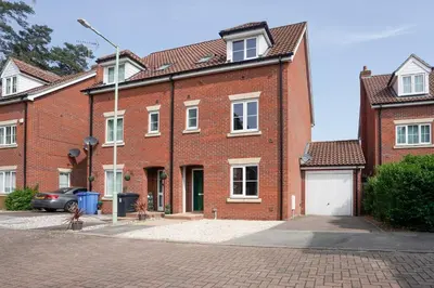 a red brick building with a white garage at Yew Tree Close Mildenhall Bury St Edmunds in Mildenhall