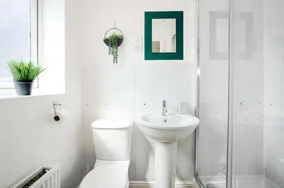 a white bathroom with a toilet and a sink at Yew Tree Close Mildenhall Bury St Edmunds in Mildenhall