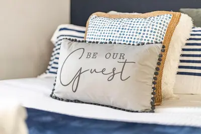 a pillow that says be our guest on a bed at Ipswich Town center Gem Sleep 5 in Ipswich