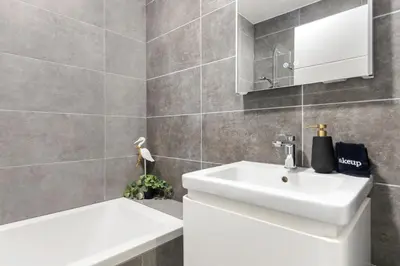 a bathroom with a white sink and a tub at Ipswich Town center Gem Sleep 5 in Ipswich