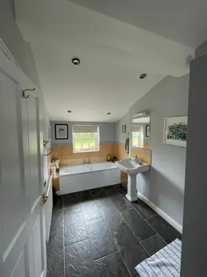 a bathroom with two sinks and a bath tub at The Grange in Attleborough