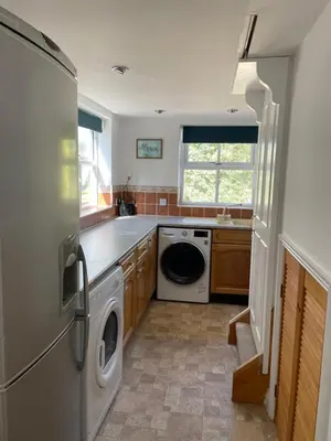 a kitchen with a refrigerator and a washer and dryer at The Grange in Attleborough