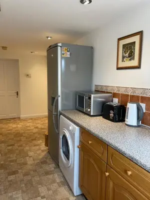 a kitchen with a refrigerator and a washing machine at The Grange in Attleborough