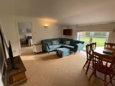 a living room with a blue couch and a table at The Grange in Attleborough
