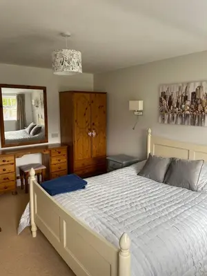 a bedroom with a white bed and a large mirror at The Grange in Attleborough