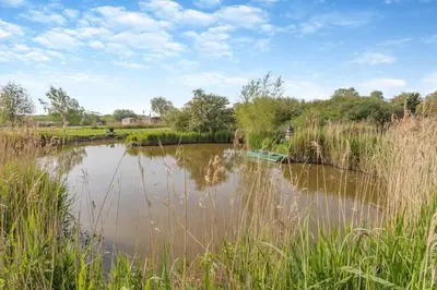 a small lake with a boat in the middle at 2 Bed in Welney oc-k29369 in Welney