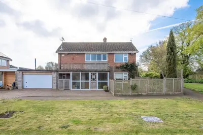 an exterior view of a brick house with a garage at 5 Toller Close, Orford in Orford
