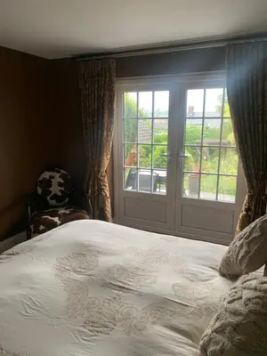 a bedroom with a large bed and a window at Boutique bungalow in Haverhill