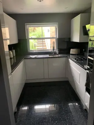 a kitchen with white cabinets and a window at Boutique bungalow in Haverhill