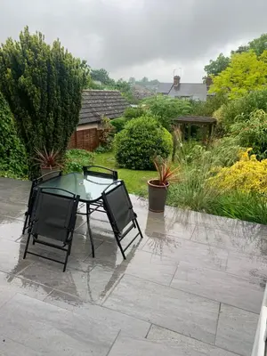 a glass table and two chairs on a patio at Boutique bungalow in Haverhill