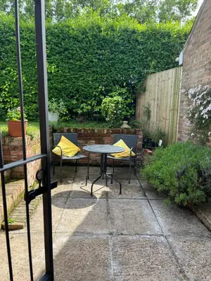 a patio with a table and chairs in a backyard at The studio spring house in Alderton