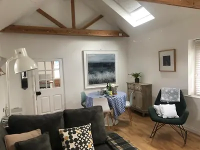 a living room with a couch and a table at The studio spring house in Alderton