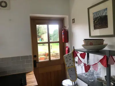 a kitchen with a window and a table with a bowl at The studio spring house in Alderton