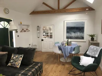 a living room with a table and a couch at The studio spring house in Alderton