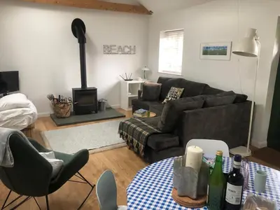 a living room with a couch and a table at The studio spring house in Alderton