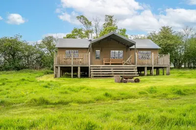 a house on a grassy field with a house at Linnet - Sweffling Hall in Rendham