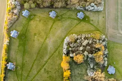 an overhead view of a field with houses and trees at Linnet - Sweffling Hall in Rendham
