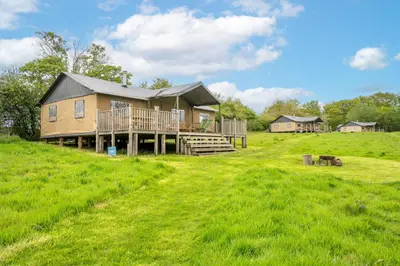 a house on a grassy hill with a yard at Linnet - Sweffling Hall in Rendham
