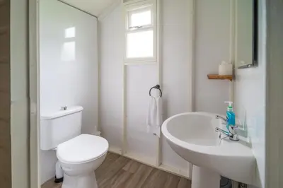 a white bathroom with a toilet and a sink at Swallow - Sweffling Hall in Rendham