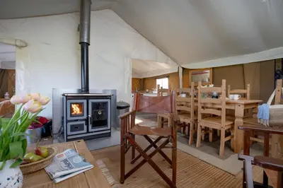 a tent with a dining room and a fireplace at Sweffling at Lantern and Larks in Rendham