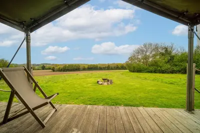 a hammock on a porch with a view of a field at Sweffling at Lantern and Larks in Rendham