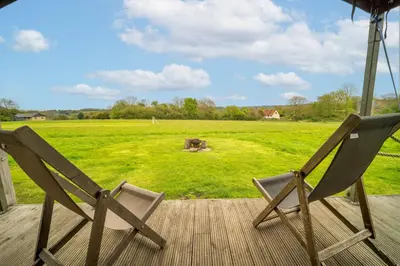 two chairs sitting on a deck looking at a field at Sweffling at Lantern and Larks in Rendham