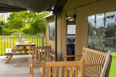 a patio with two chairs and a table on a deck at Swift - Sweffling Hall in Rendham