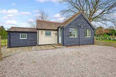 a blue and white house with a driveway at The Willows in Great Horkesley