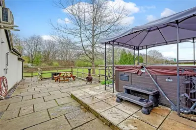 a pavilion with a dog house and a grill at The Willows in Great Horkesley