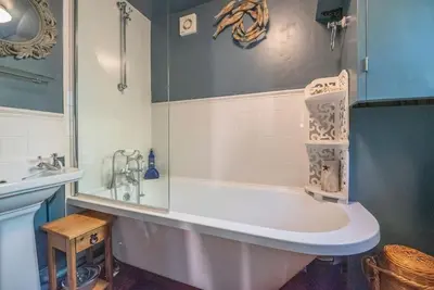 a bathroom with a bath tub and a sink at 2 Fox Cottage, Darsham in Darsham