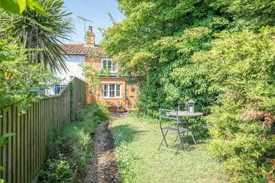 a small garden with a table and a fence at 2 Fox Cottage, Darsham in Darsham
