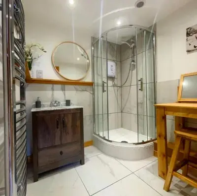 a bathroom with a shower and a sink and a mirror at Captivating 1-Bed Cabin in Newmarket in Newmarket