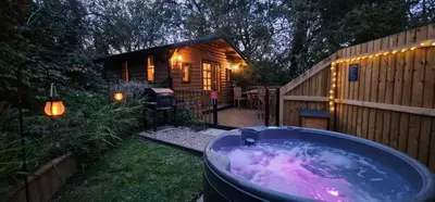 a hot tub in the yard next to a cabin at Captivating 1-Bed Cabin in Newmarket in Newmarket