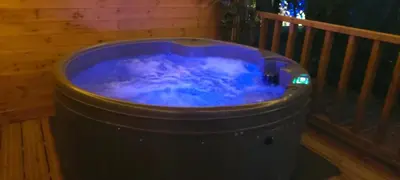 a large hot tub sitting on a wooden deck at Beautiful 1-Bed Cabin in Newmarket in Newmarket