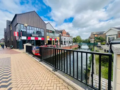 a city with a river and buildings and a bridge at Chelmsford City Centre Modern Duplex With Parking, Wi-Fi & Netflix in Chelmsford