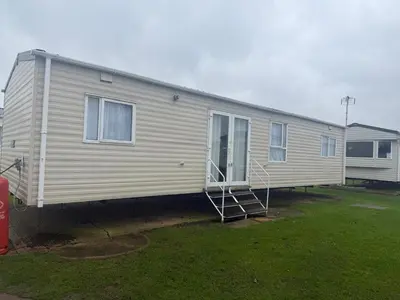 a mobile home is parked in a yard at 6 Bed Static Carvan Seawick Holiday Park in Saint Osyth