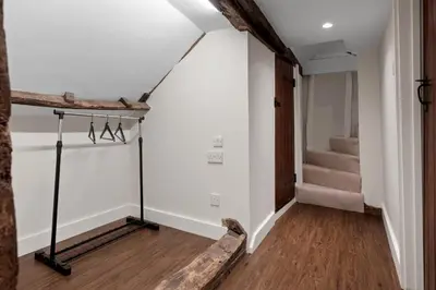 a hallway with white walls and stairs with a wooden floor at Beautiful period property in historic town in Braintree