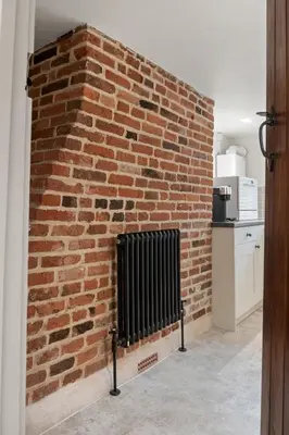 a brick wall with a fireplace in a kitchen at Beautiful period property in historic town in Braintree