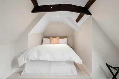 a bedroom with a white bed in a attic at Beautiful period property in historic town in Braintree