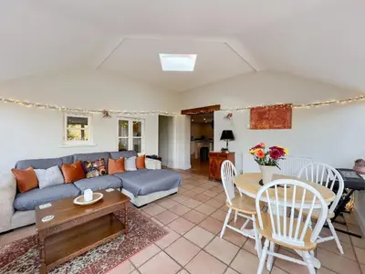 a living room with a blue couch and a table at Sandy Toes Cottage in Beechamwell