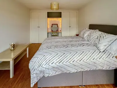 a large bed in a room with a desk and a bed sidx sidx sidx at Sandy Toes Cottage in Beechamwell