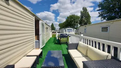 a patio with two benches and a table on the side of a house at SKYLA VISTA Deluxe in Clacton-on-Sea
