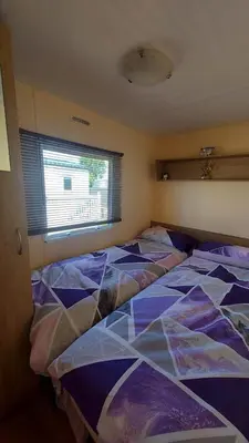 a bedroom with three beds and a window at SKYLA VISTA Deluxe in Clacton-on-Sea