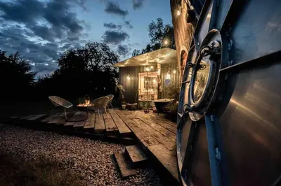 a house with two chairs and a table in front of it at Unique glamping experience near Ely & Cambridge in Ely