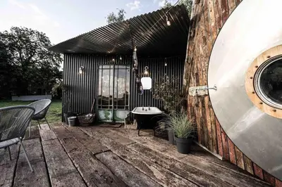 a patio with a table and chairs and a building at Unique glamping experience near Ely & Cambridge in Ely