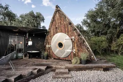 a pyramid house with a toilet in the middle at Unique glamping experience near Ely & Cambridge in Ely