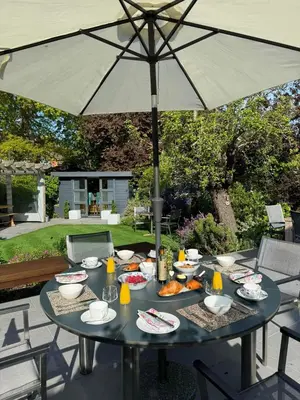 a table with food and an umbrella on a patio at Frinton45 in Frinton-on-Sea