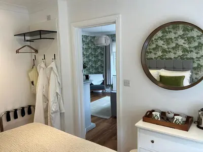 a room with a mirror on the wall and a bedroom at Frinton45 in Frinton-on-Sea